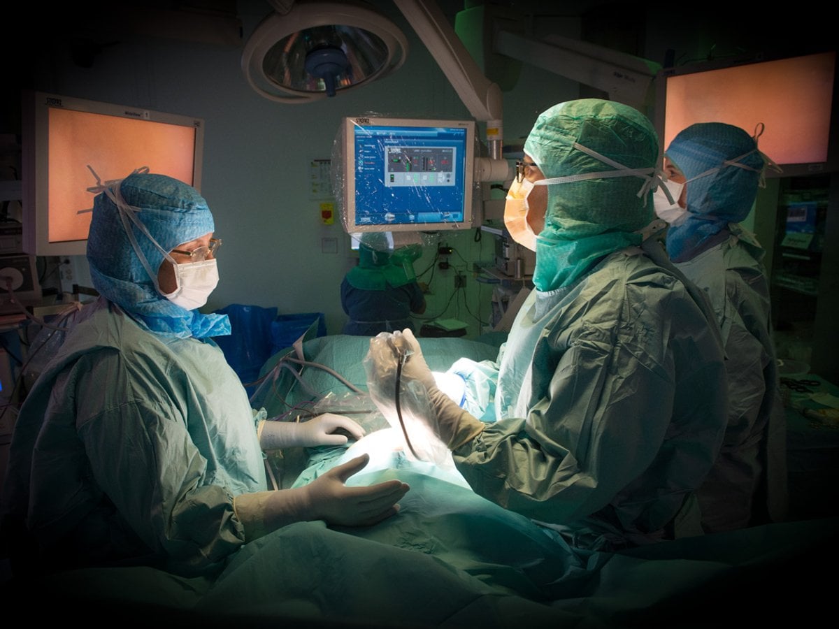 3 personer som är operationsklädda i en operationssal