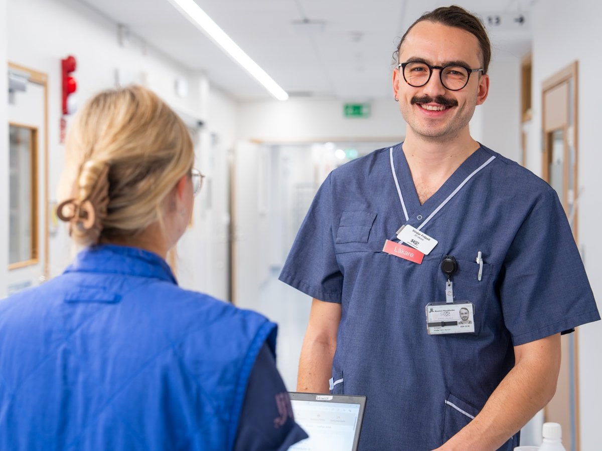 manlig läkare i samtal med kvinnlig hälso- och sjukvårdspersoanl