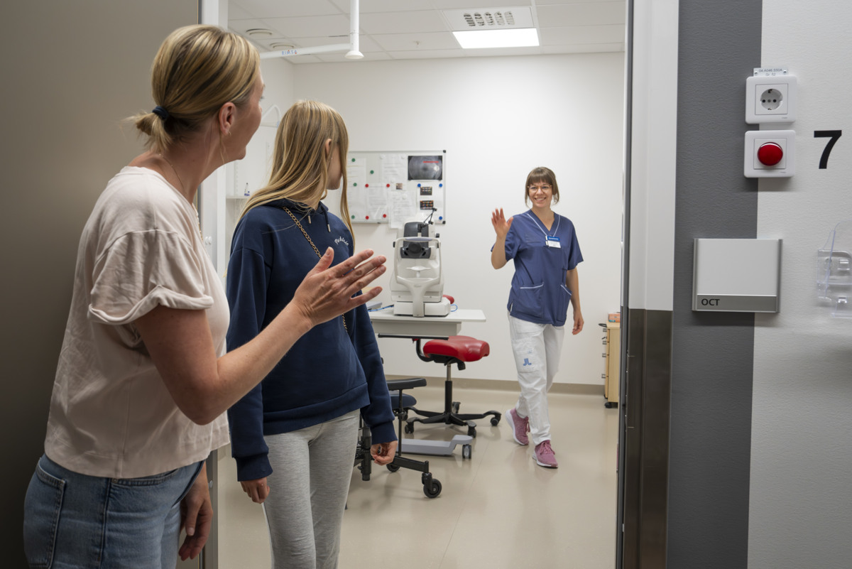 En ung och en &auml;ldre kvinna som vinkar hejd&aring; till en sjuksk&ouml;terska.