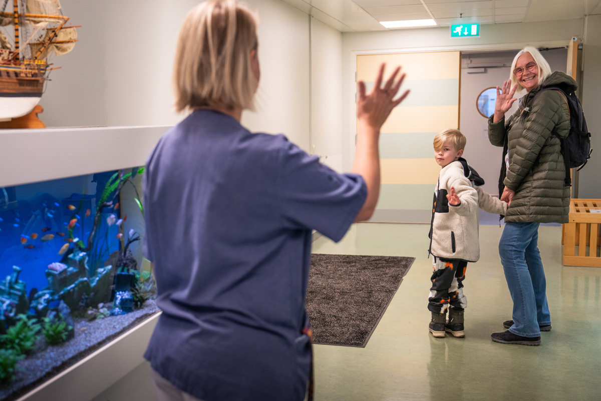 En sjuksk&ouml;terska vinkar hejd&aring; till ett liten pojke och en &auml;ldre dam