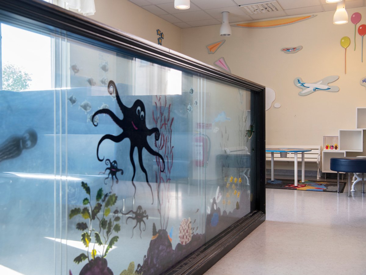Bild på ett akvarium med målade fiskar i ett väntrum 