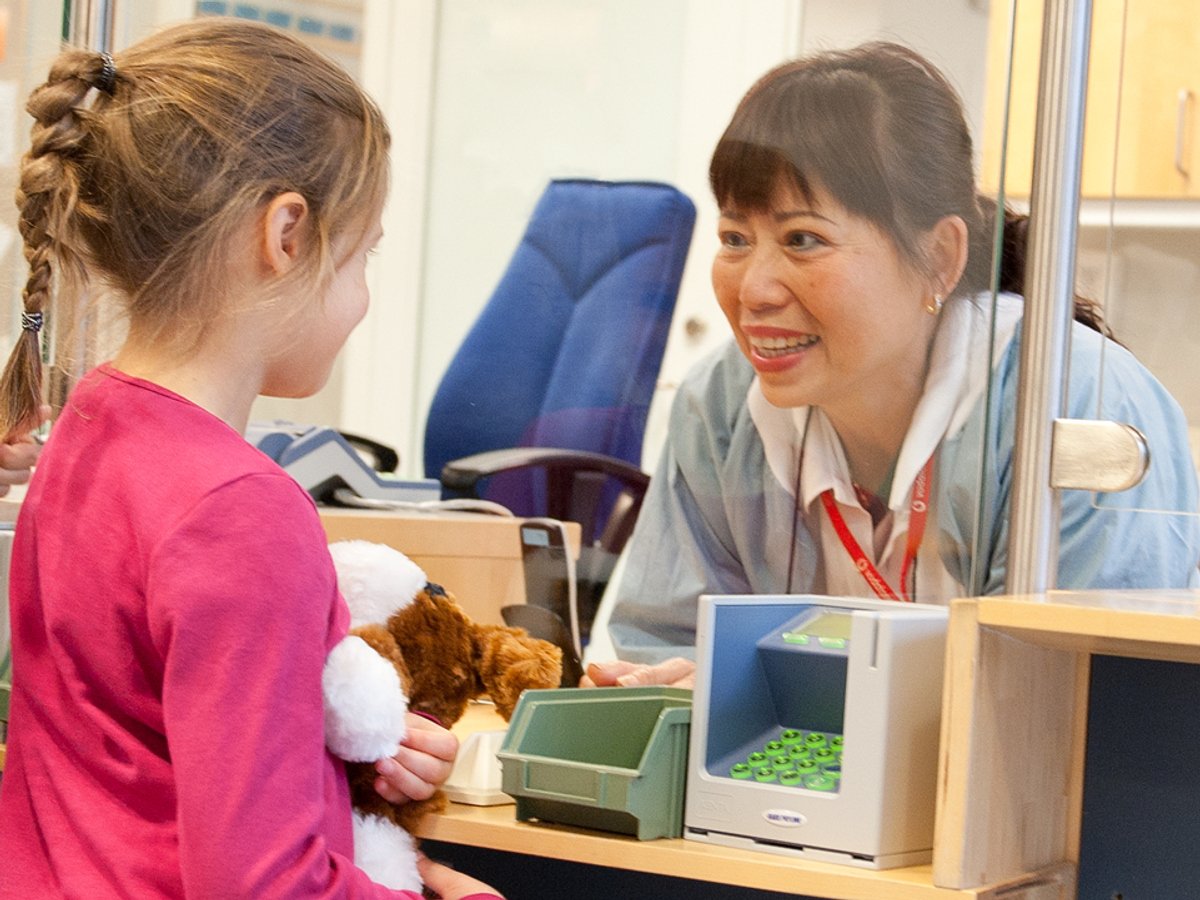 Ung flicka pratar med en receptionist 