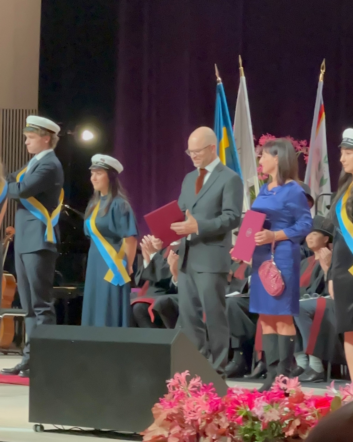 Anders Sonden tar emot pris på scen där studenter också står
