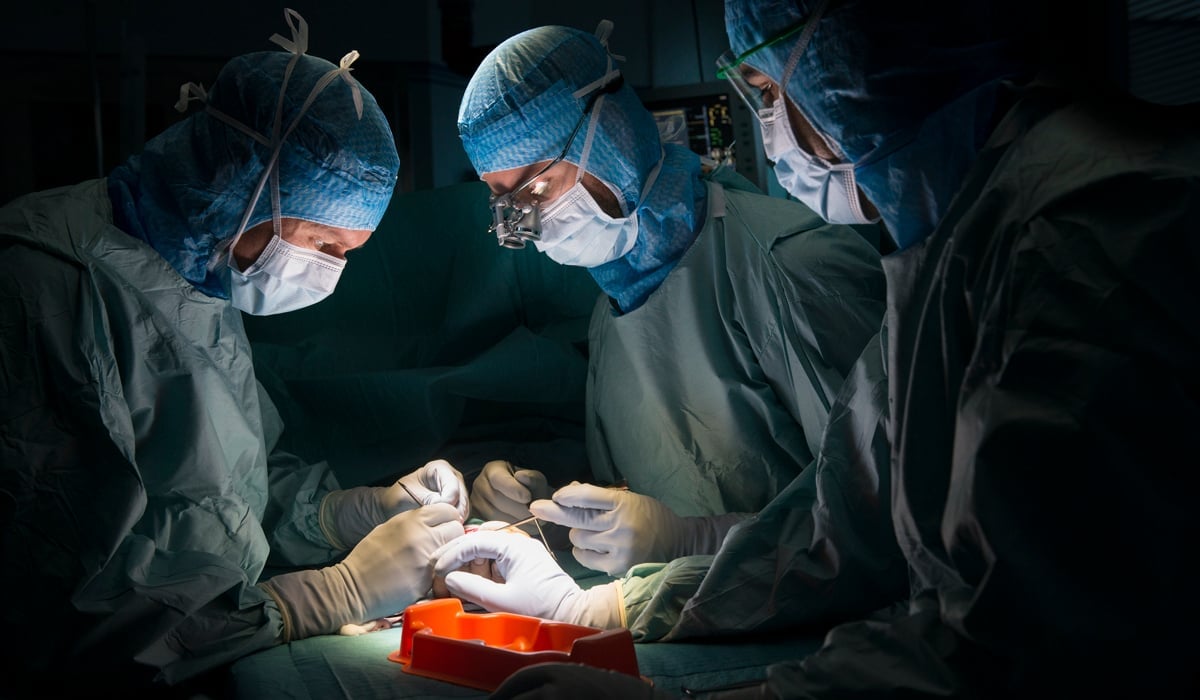 Bild på operationspersonal som opererar på en hand