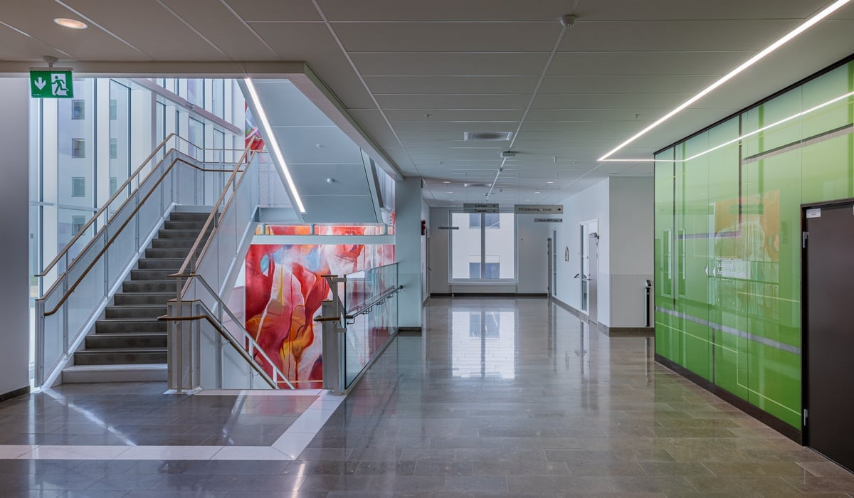 trapphus med grön vägg och konstverk i bakgrund