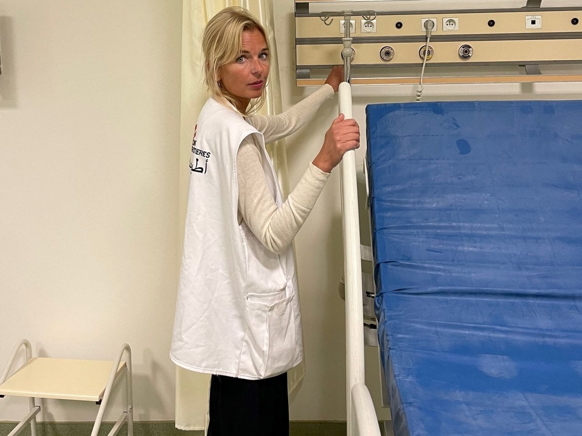 Märit Halmin står vid en sjukhussäng klädd i en vit väst från läkare utan gränser