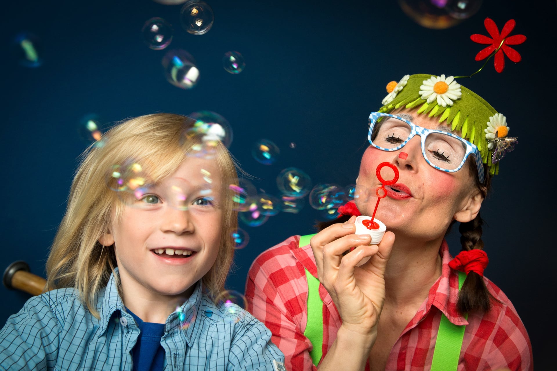 Bild på en ung pojke och en kvinna utklädd till clown