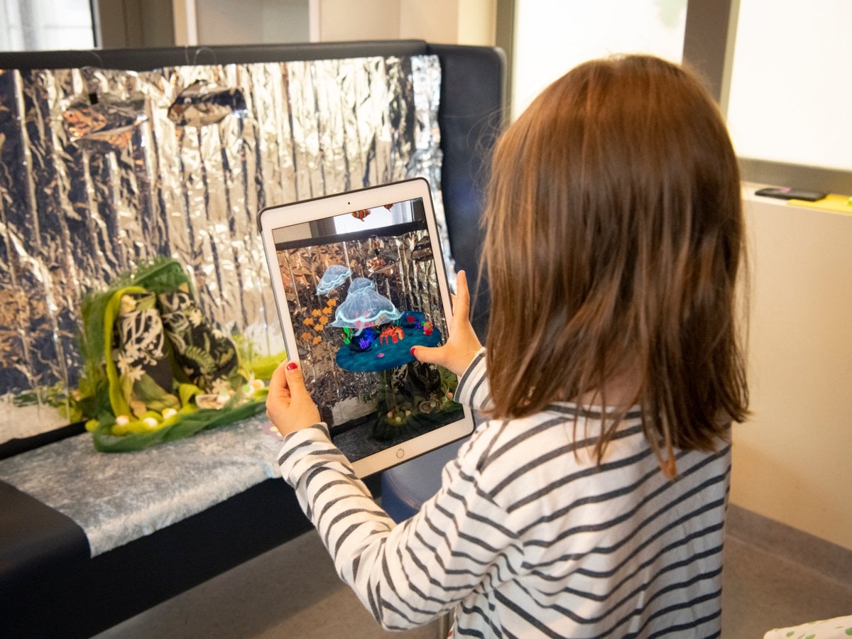 Bild på ett barn som leker med en stor skärm