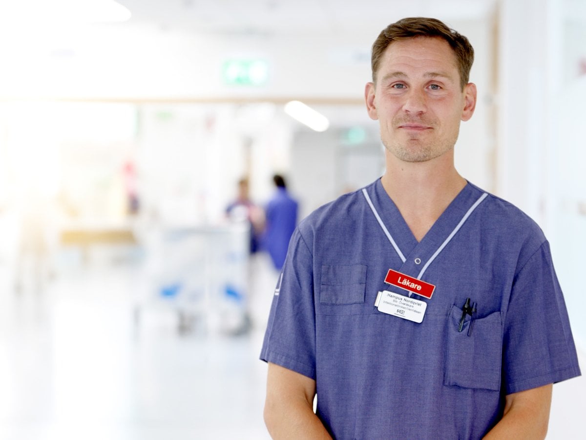 Läkare med sjukhuskläder som står på en sjukhusavdelning