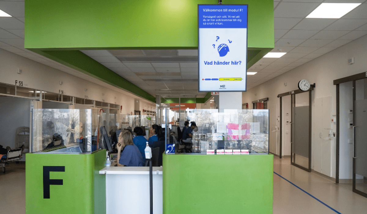 grön moudl med personal, bildskärm med texten Vad händer här?