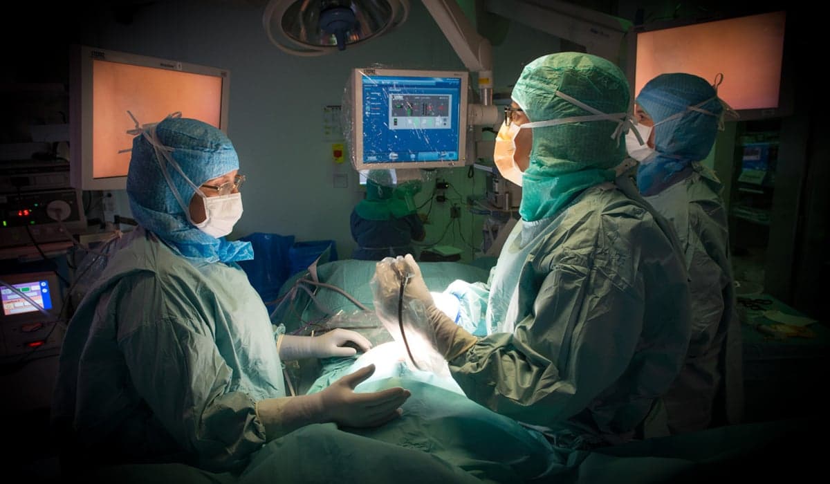 3 personer som är operationsklädda i en operationssal