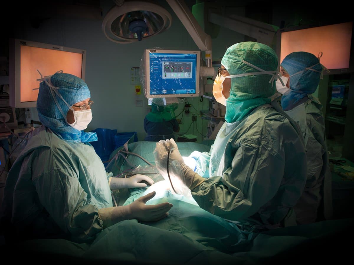 3 personer som är operationsklädda i en operationssal