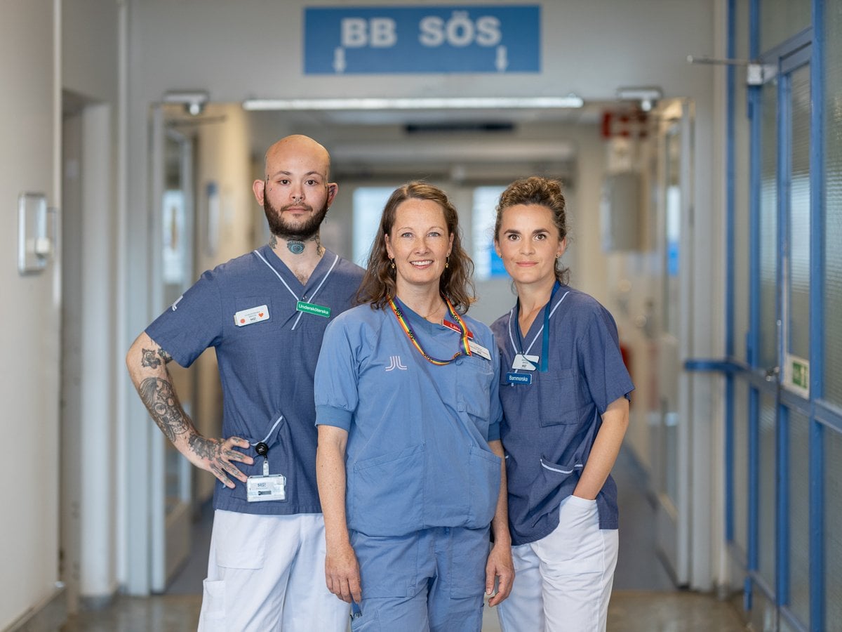 tre medarbetare tillsammans framför skylt till BB Sös