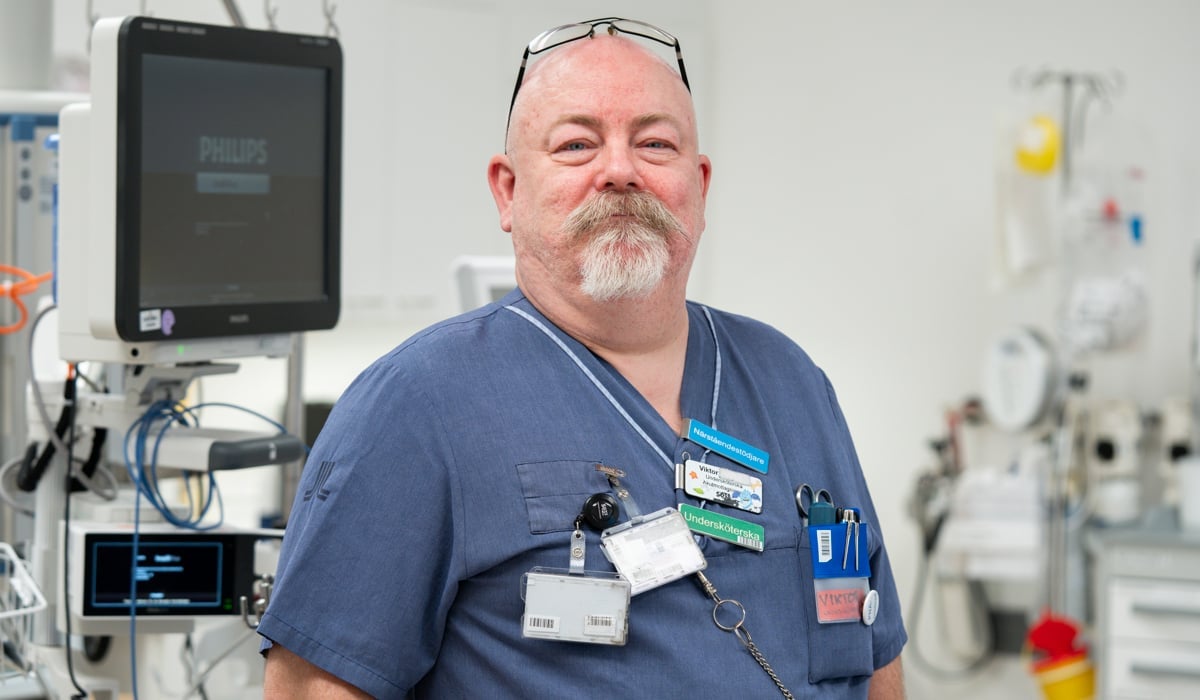 man i sjukhuskläder i ett sjukhusrum