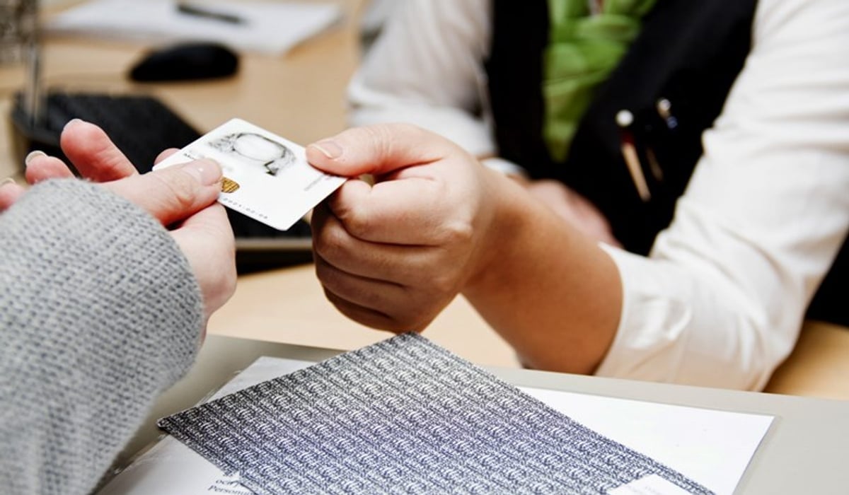 Två personer som håller i ett Etjänstekort