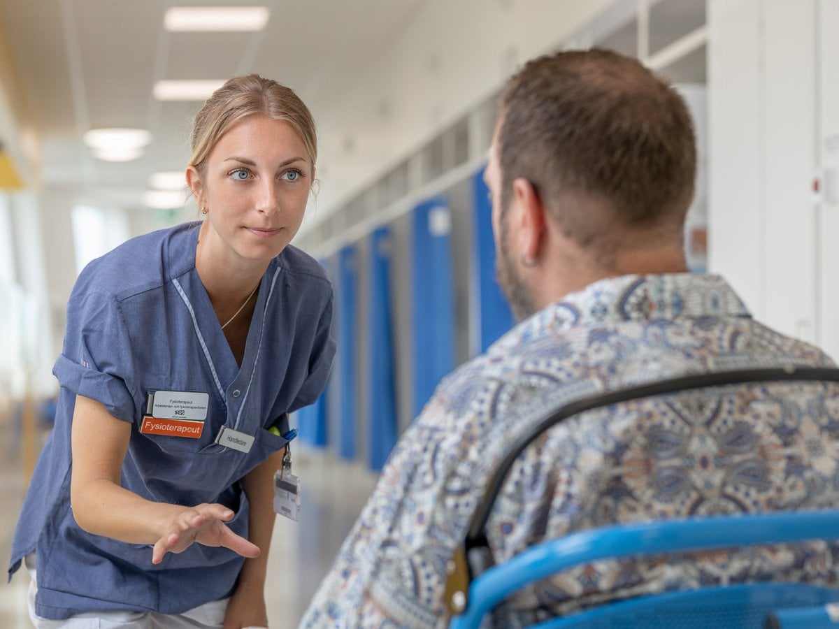 kvinnlig fysioterapeut samtalar med sittande patient