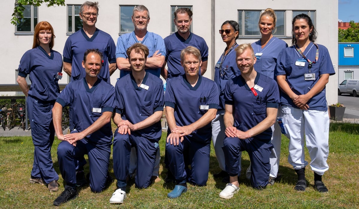 gruppbild utomhus av sjukhusklädda medarbetare