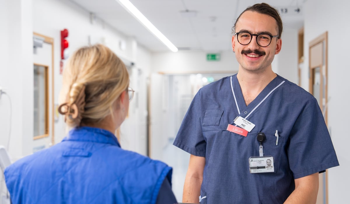 manlig läkare i samtal med kvinnlig hälso- och sjukvårdspersoanl