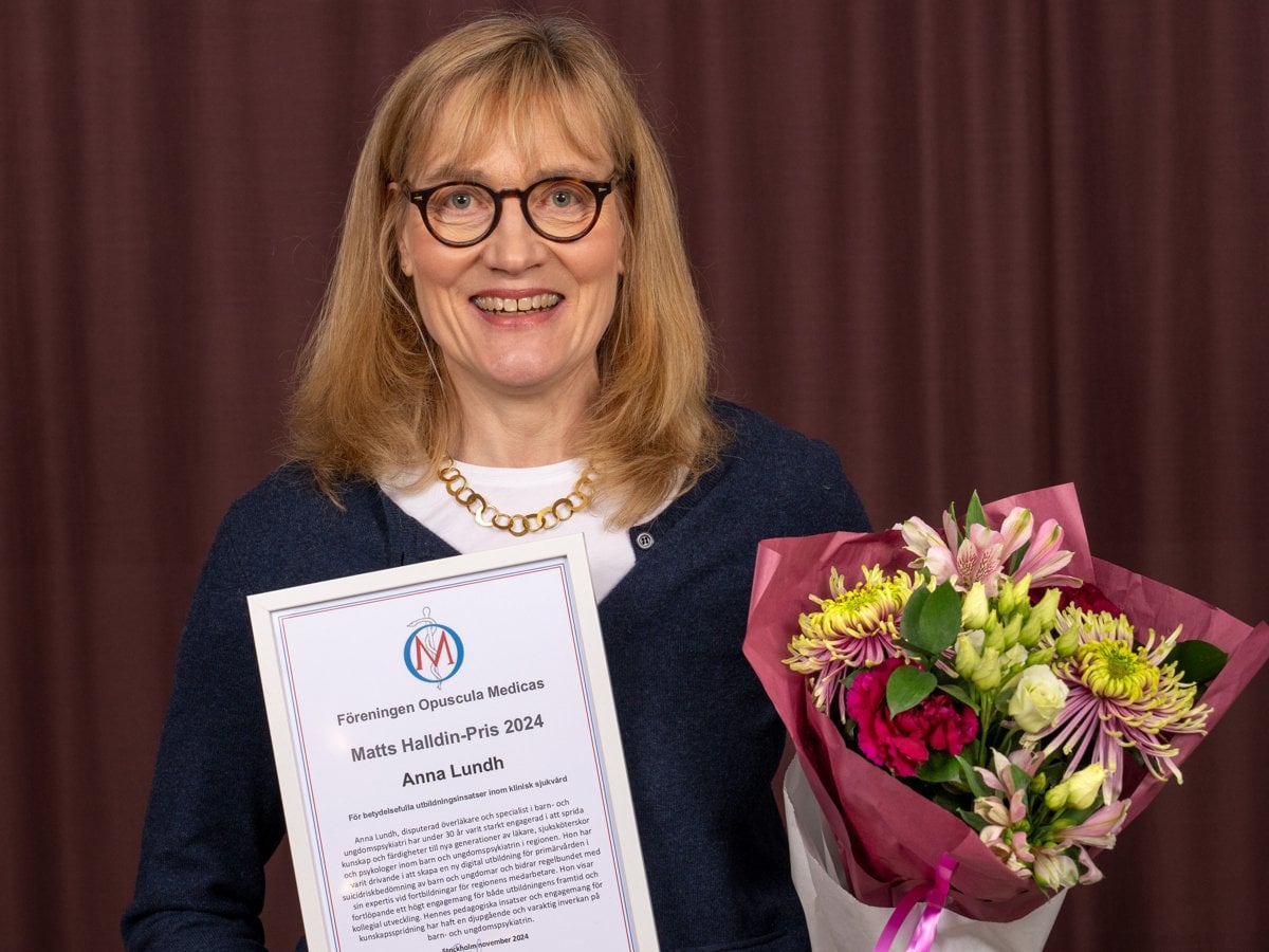 Anna Lundh med diplom i ena handen, blombukett i andra.