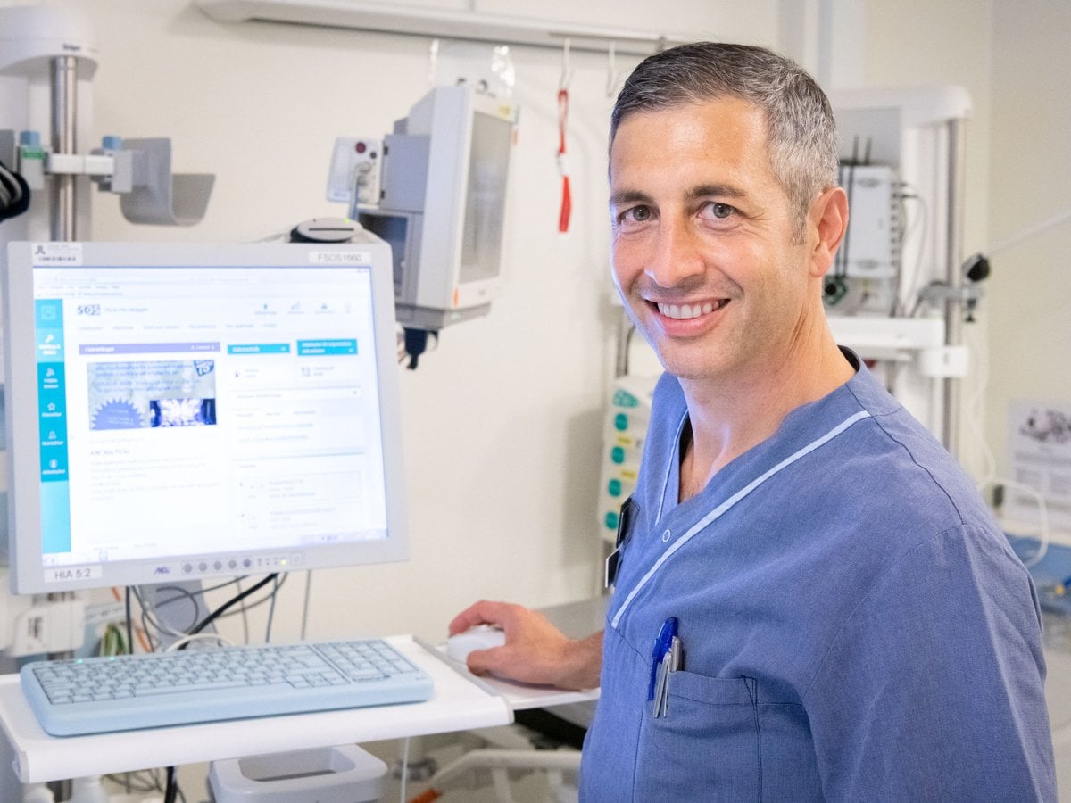 Robin Hofmann sjukhusklädd framför dator