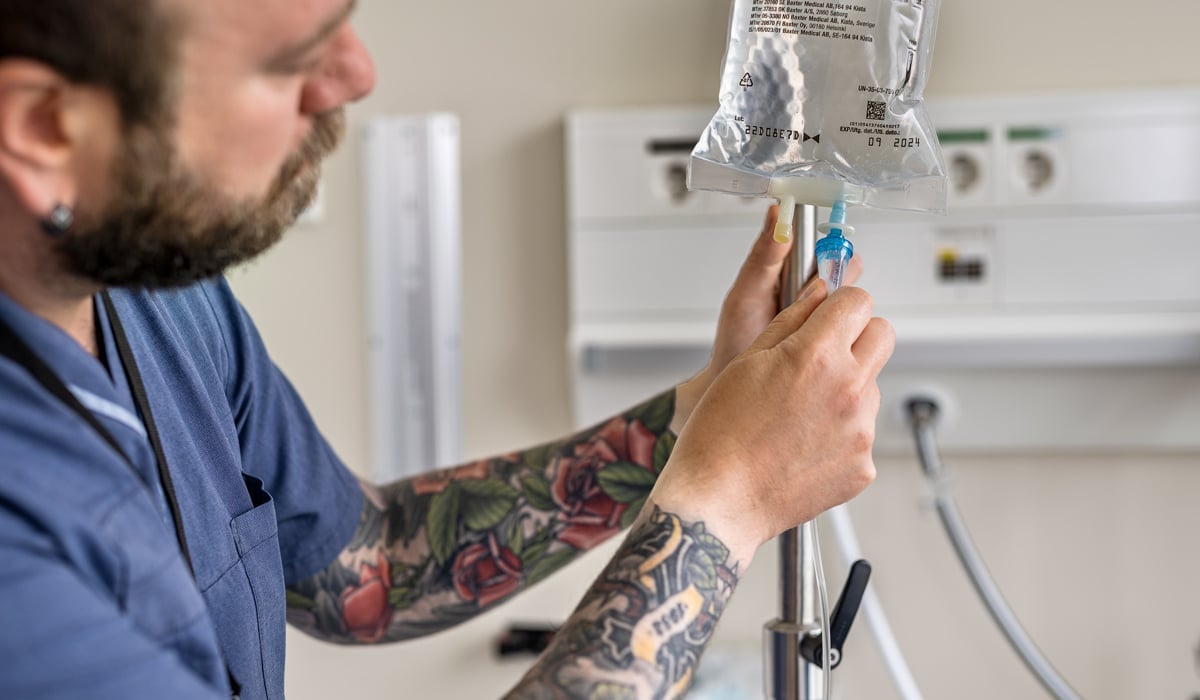 man med tatueringar på armarna ordnar droppställning