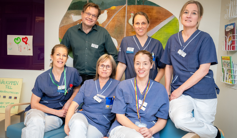 gruppbild personer som sitter i och står bakom soffa