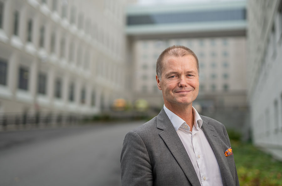 Johannes Blom i utomhusmiljö, sjukhusbyggnader i bakgrund