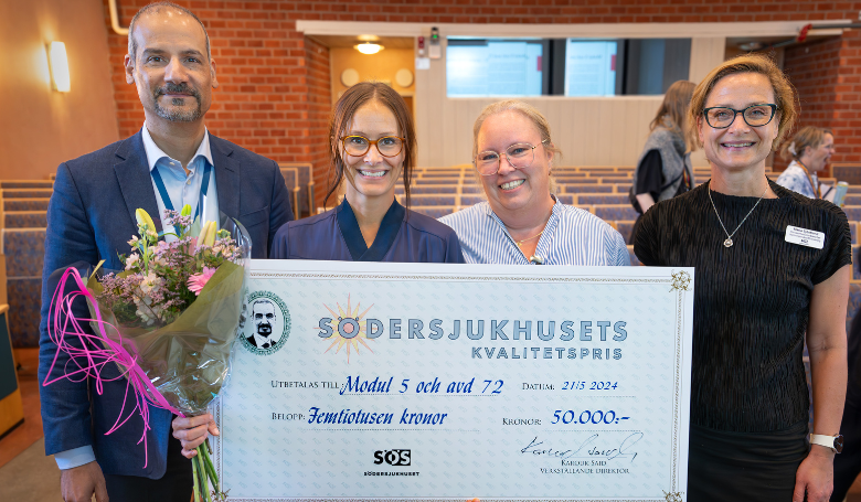 gruppbild en man tre kvinnor håller stor papperscheck framför sig